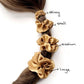copper brown mulberry silk scrunchies hair ties of different sizes on a ponytail with labeled sizes.