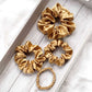 Set of copper brown mulberry silk scrunchies hair ties on a wooden surface
