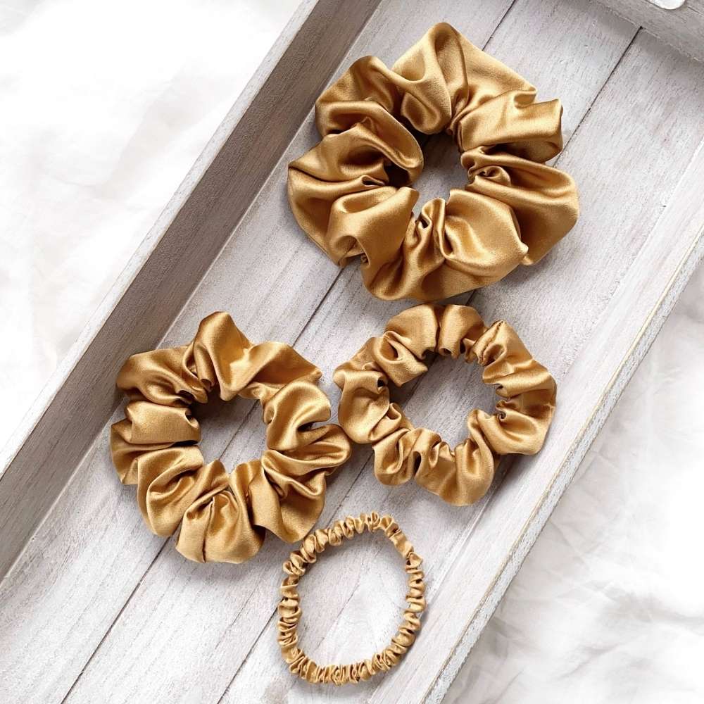Set of copper brown mulberry silk scrunchies hair ties on a wooden surface