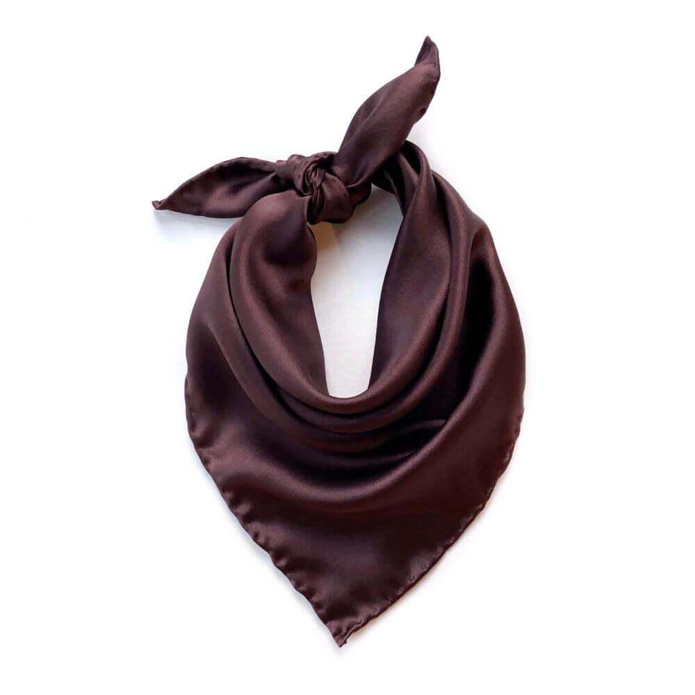 Brown silk scarf tied in a knot on a white background
