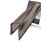 Dark taupe silk satin scarf laid over a book with smooth sheen