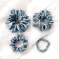 Set of four blue silk hair scrunchies on the white background