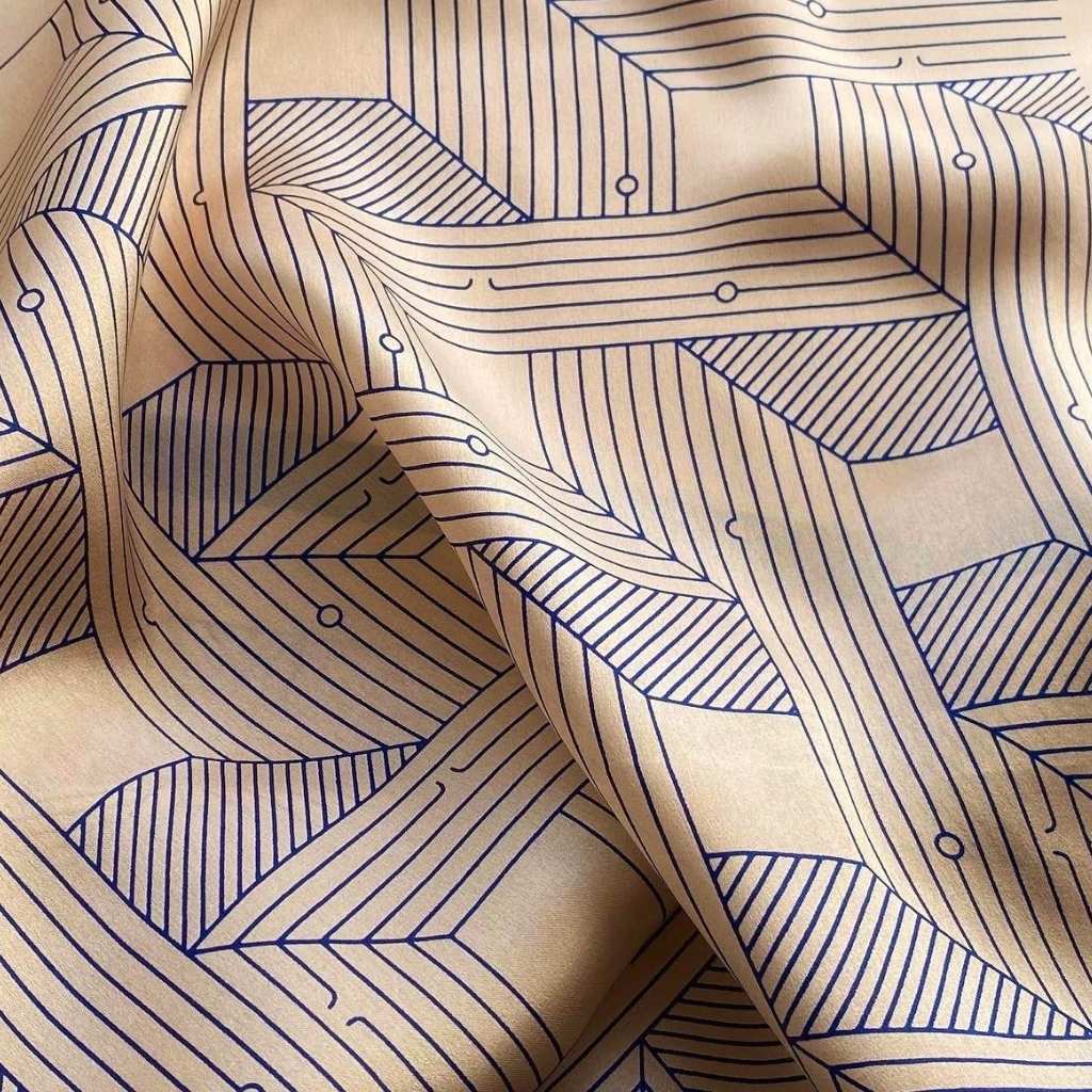Dusty rose pink mulberry silk scarf with a navy blue geometric line pattern, shown in soft folds.