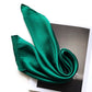 Close-up folded emerald green silk satin scarf on a magazine