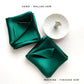 Hand-rolled and machine-finished hems displayed in emerald green silk