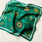 Emerald green mulberry silk square scarf featuring a compass print, displayed flat on a white background.