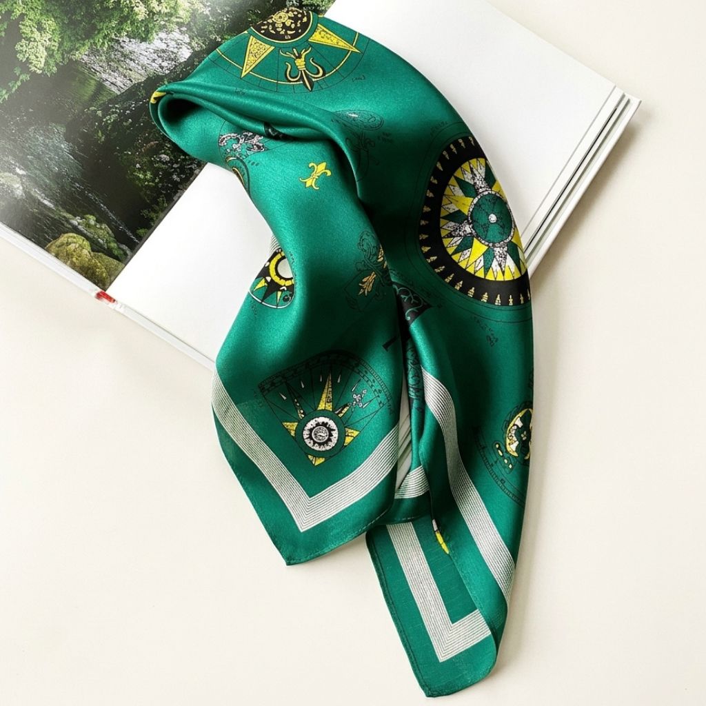 Emerald green mulberry silk square scarf featuring a compass print, displayed on a white background.