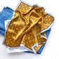 Flat mustard Yellow mulberry silk square scarf with beige cream polka dots print  on a blue jeans placed on the white background