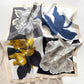 Floral patterned mulberry silk square scarf with blue, yellow, and white flowers with cream border on a white background