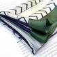 folded blue white and green mulberry silk scarf with geometric pattern on a magazine page