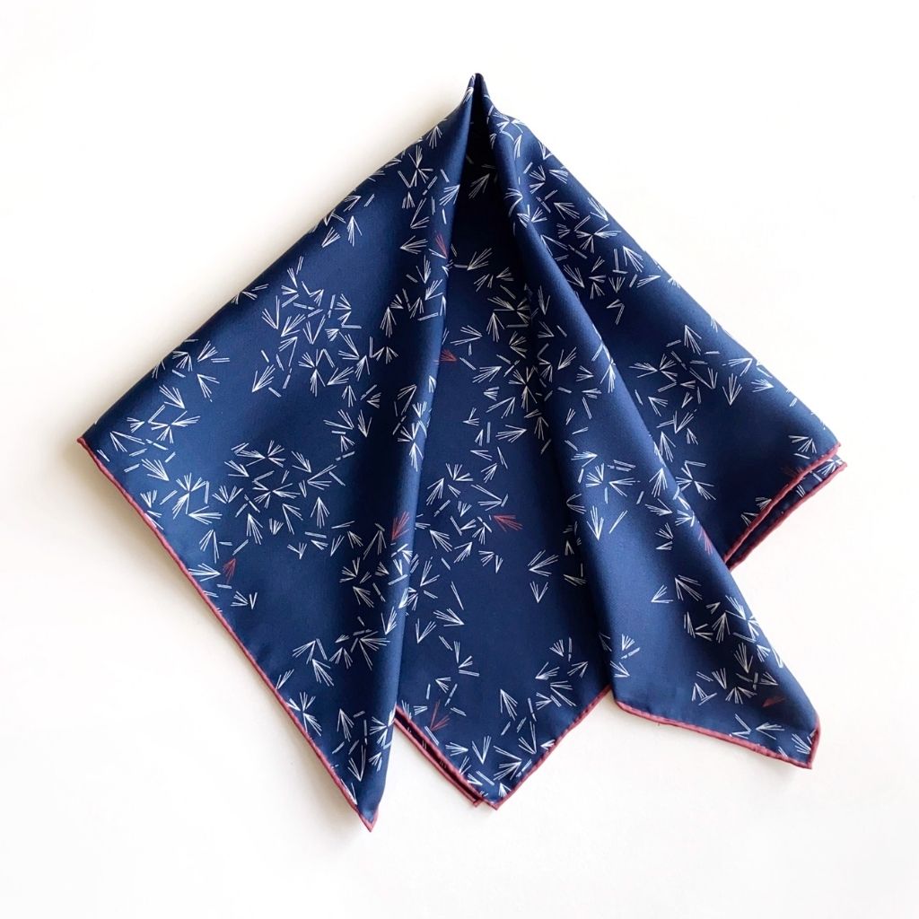 Folded River Minami square mulberry silk scarf in navy blue with white geometric prints and red trim.