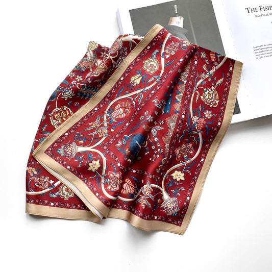 Red floral patterned mulberry silk square scarf on a white surface
