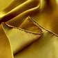 Close-up of yellow silk scarf with a folded corner