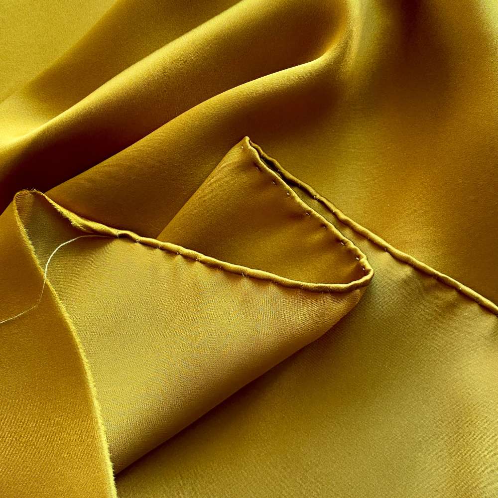 Close-up of yellow silk scarf with a folded corner