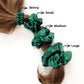 Green mulberry silk satin scrunchies and hair ties of different sizes on a ponytail with labeled sizes.