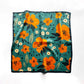 53cm square Floral patterned mulberry silk scarf with orange flowers on a teal green background laid flat on the white background