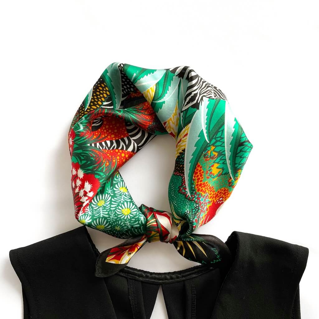 green red yellow mulberry silk neckerchief tied around a black dress on a white background