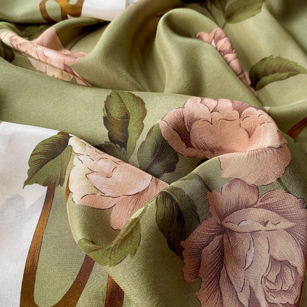 Close-up of a floral-patterned fabric with pink and green flowers on a light background