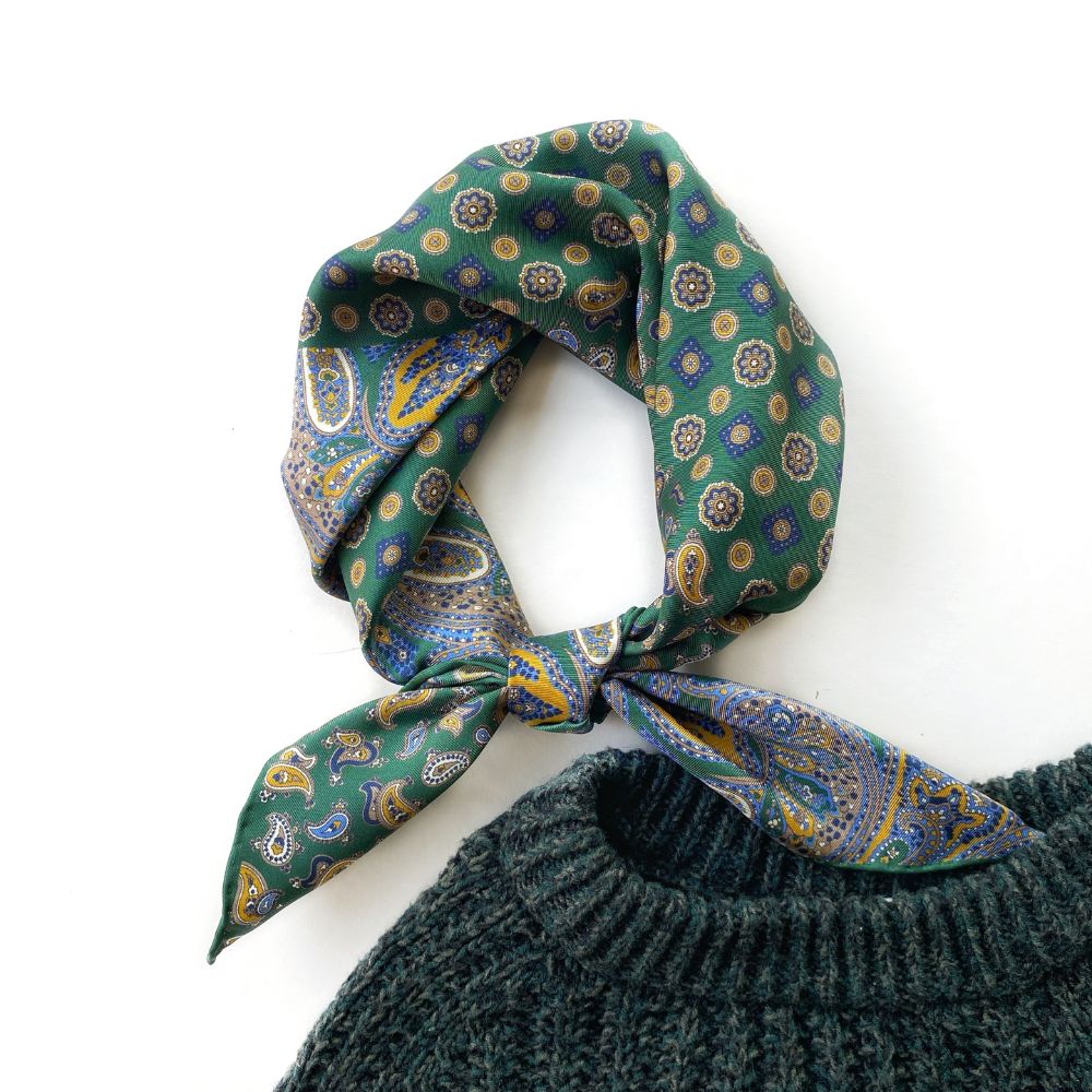 Green paisley and geometric patterned mulberry silk square scarf on a white background