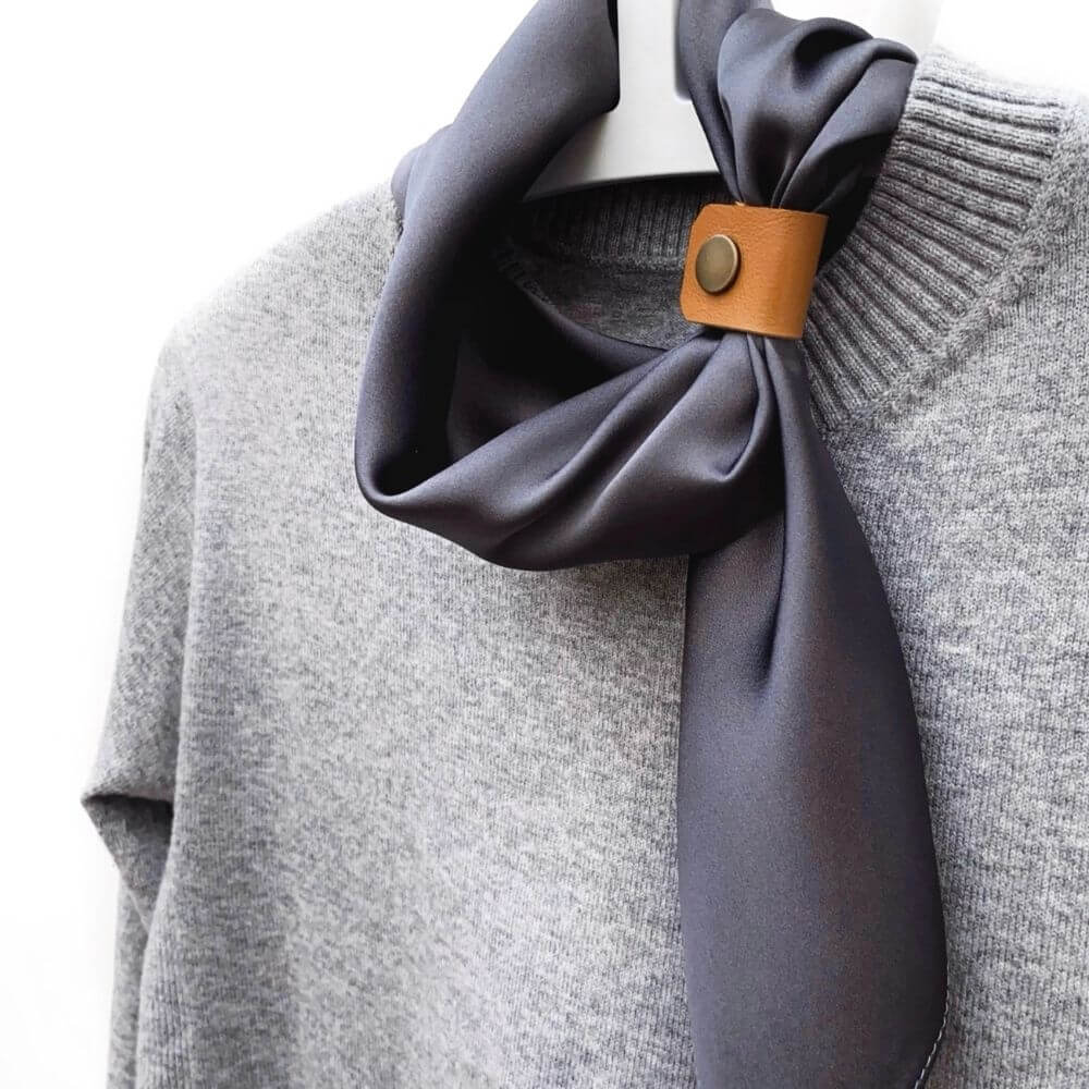 Slate grey mulberry silk satin square scarf displayed in a loose loop on a grey knit sweater with a tan leather scarf ring.