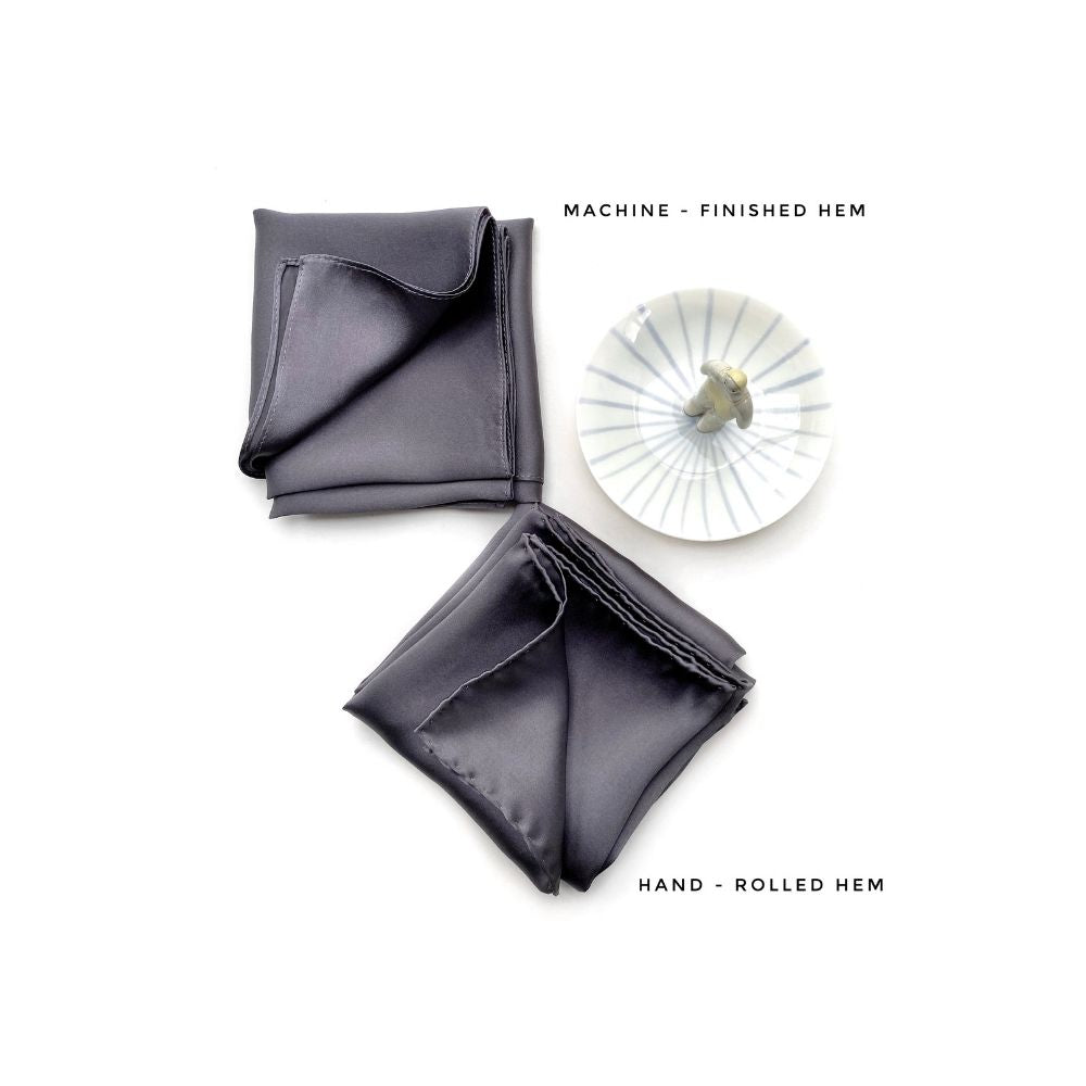 Comparison image showing machine-finished hem and hand-rolled hem options in slate grey silk satin.