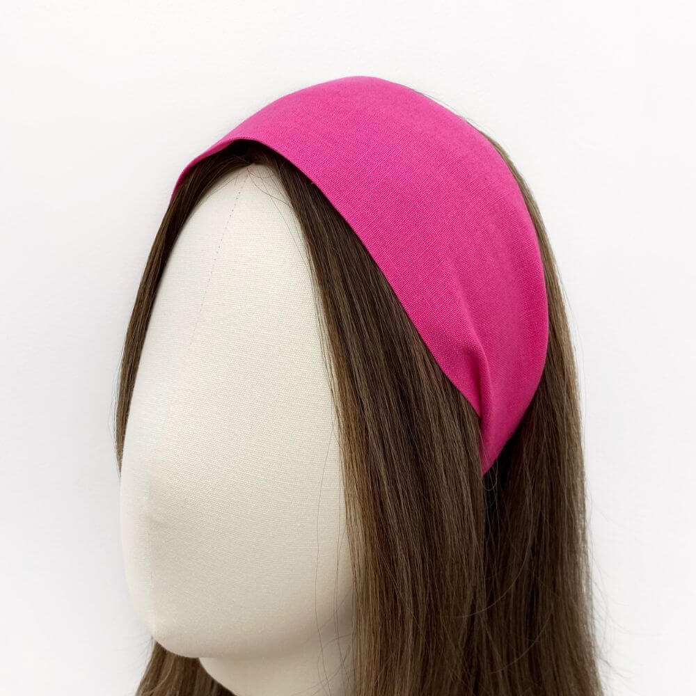 Mannequin head with hot pink linen headband on a white background