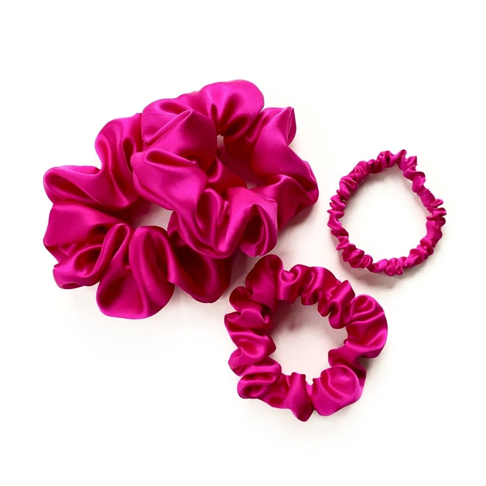 set of hot pink pure mulberry silk satin scrunchies and hair ties on the white background