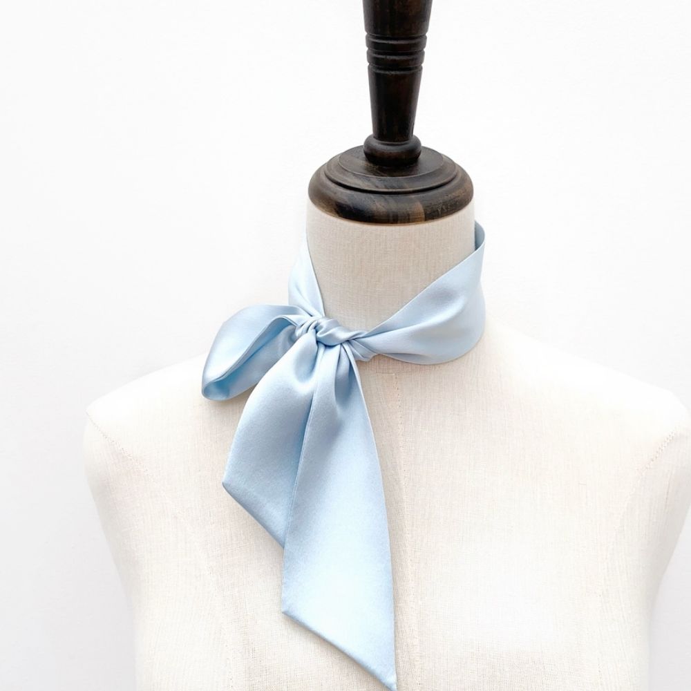light blue mulberry silk satin skinny scarf tied around mannequin's neck