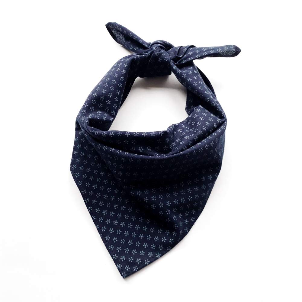 Navy blue bandana with small white floral patterns on a white background