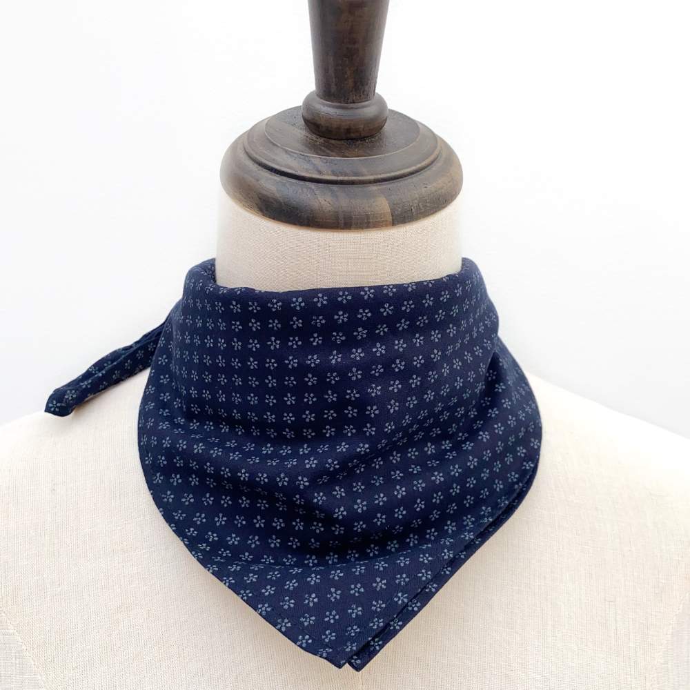 Navy blue bandana with white floral pattern on a mannequin head.