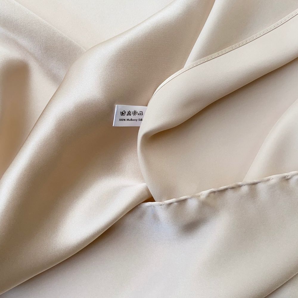 Close-up of Pearl Cream silk satin fabric showing smooth sheen