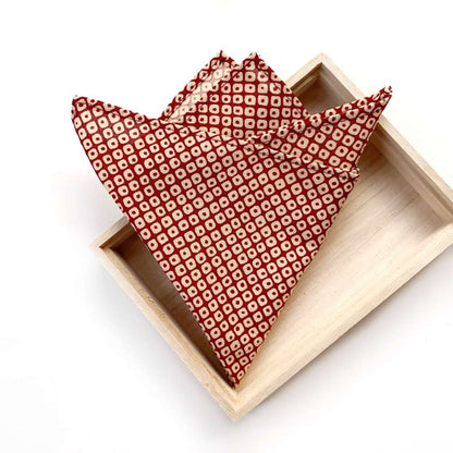Red japanese cotton packet square folded in half on a wooden tray with a white background