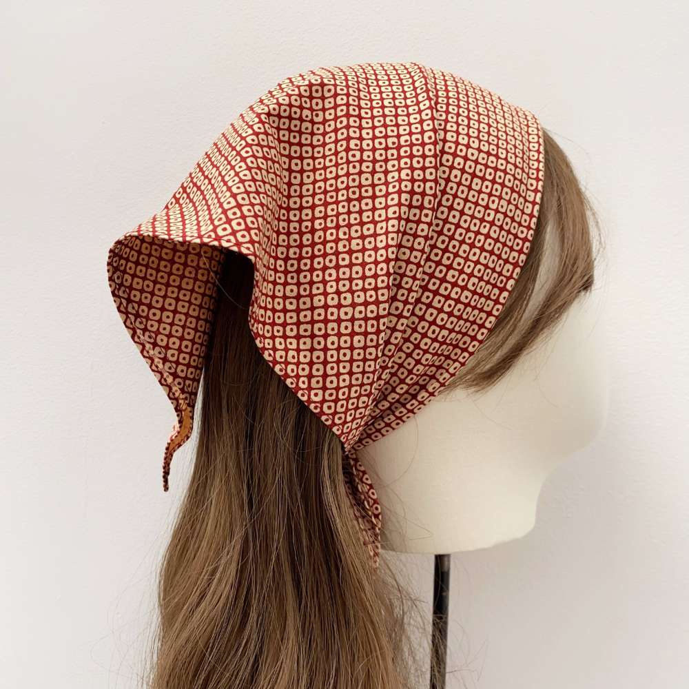 Japanese cotton bandana headscarf on a mannequin head with brown hair against a white background