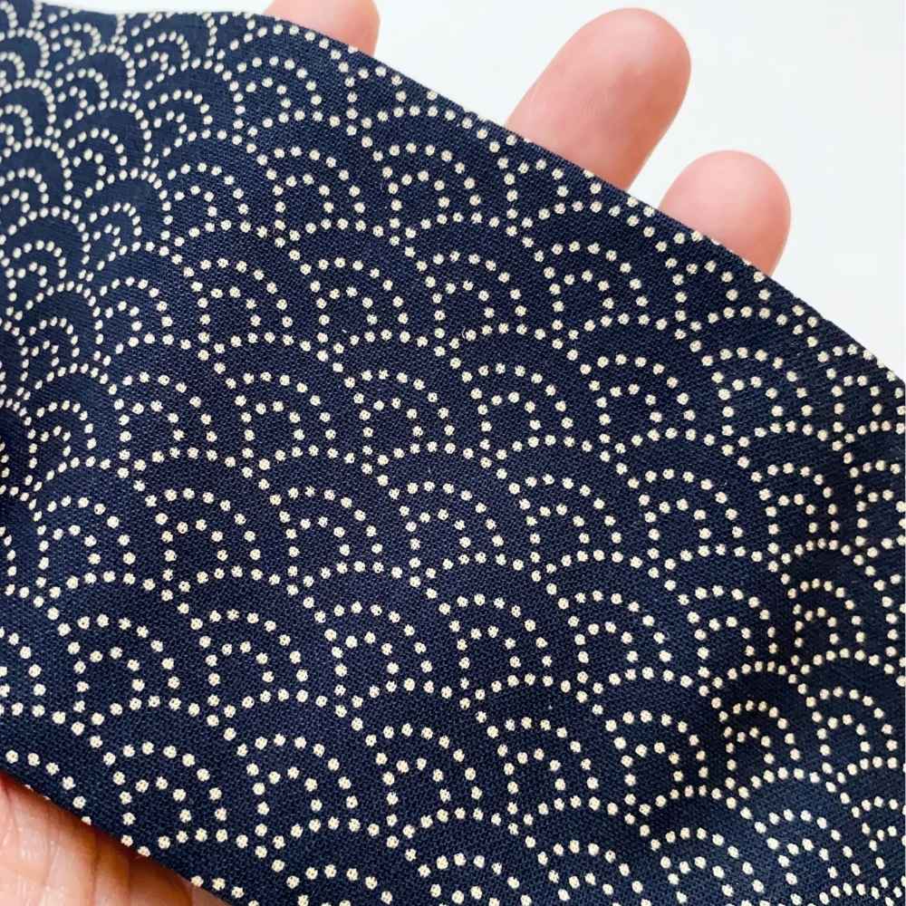 A close-up of a navy blue japanese wave cotton headband