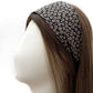 A black floral print cotton fabric headband displayed on a white mannequin head