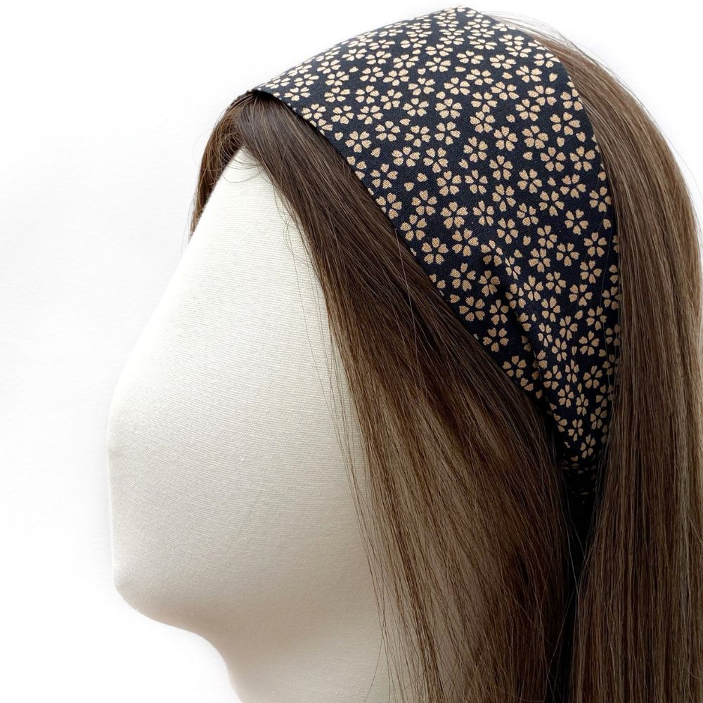 A black floral print cotton fabric headband displayed on a white mannequin head