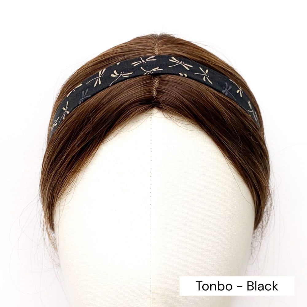 Black skinny cotton headband with dragonfly pattern on a mannequin head against a white background