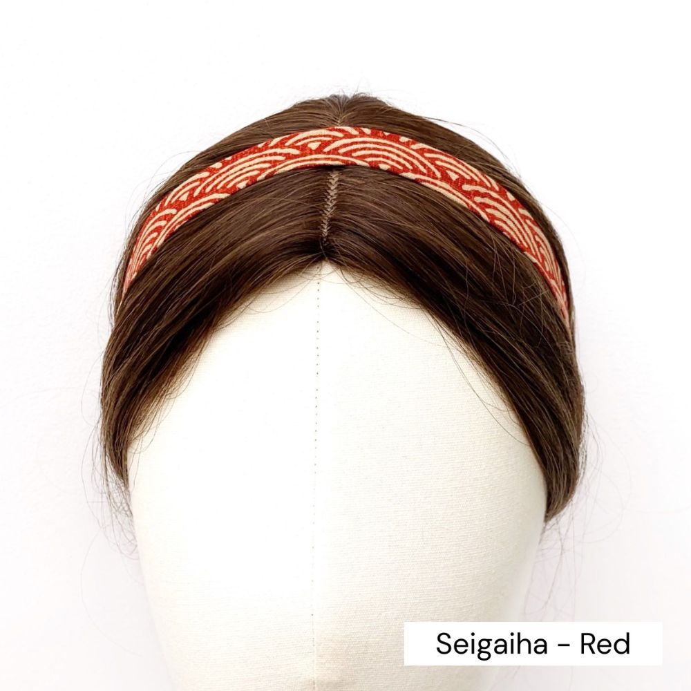Red skinny cotton headband with a Japanese wave pattern on a mannequin head against a white background