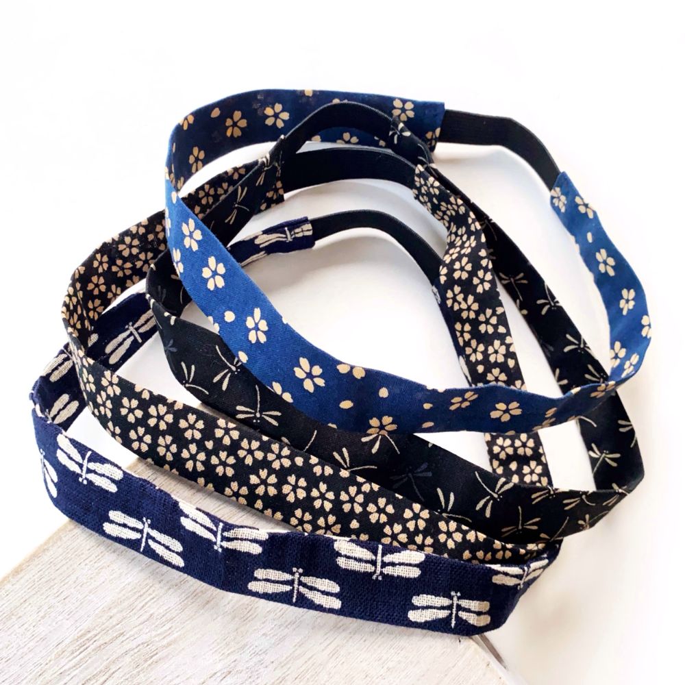 Set of blue and black cotton skinny  headbands with floral and dragonfly patterns on a white surface