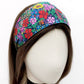 Liberty Ciara floral cotton headband displayed on a mannequin, showing the wide flat band in bright multicoloured flowers.