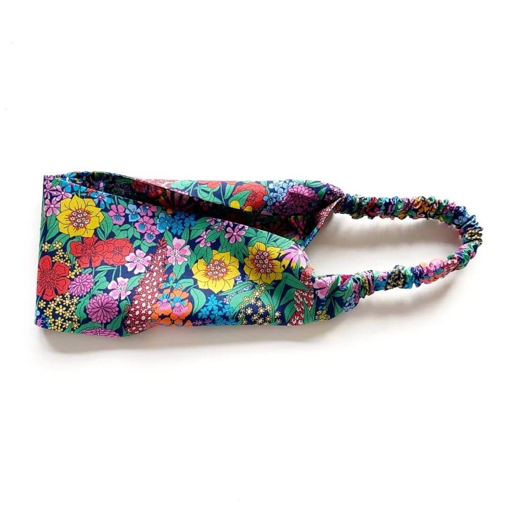 Flat-lay of the Liberty Ciara print headband, highlighting the colourful floral pattern and wide 8 cm band.