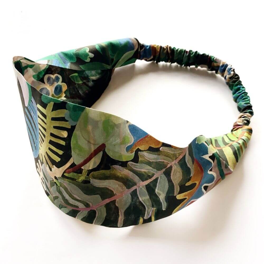 Flat-lay of the Liberty Jungle Trip cotton headband, showing the wide front band and gathered elastic back.