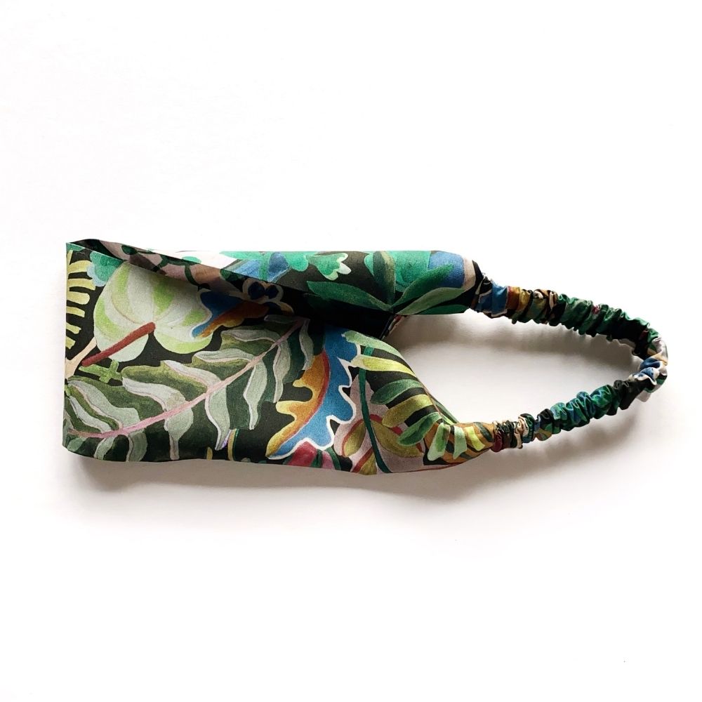 Liberty Jungle Trip cotton headband with flat front and elastic back, shown in a curved view highlighting the vibrant botanical print.