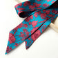 Floral patterned liberty silk skinny scarf with pink flowers on a blue background