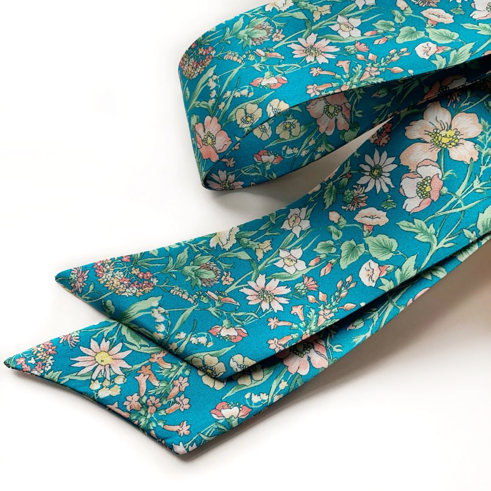 Floral-patterned Liberty silk twilly scarfon a white background