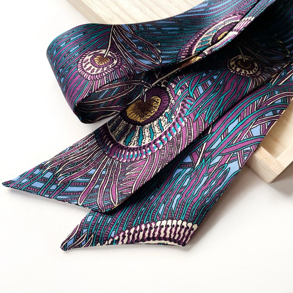 Liberty of London silk satin skinny scarf featuring the Royal Hera peacock print on a white background