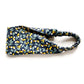 A Liberty London Tana Lawn cotton headband with a navy blue background and a yellow, white, and green citrus fruit pattern, featuring a gathered elastic back, shown on a white background.