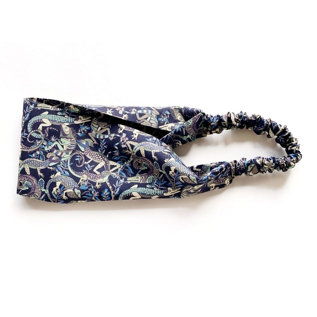 Liberty London Tana Lawn cotton headband with a dark navy blue background and a detailed animal print.