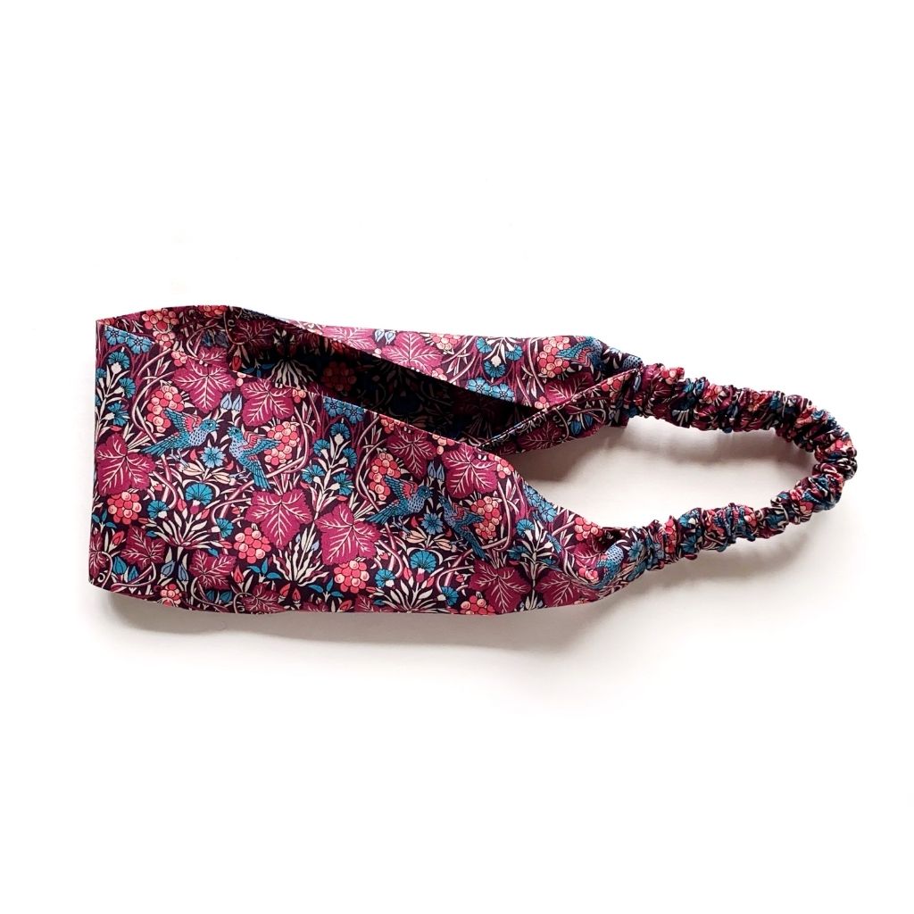 Liberty London Tana Lawn cotton headband with a dense floral and birds pattern in magenta, blue, and white.