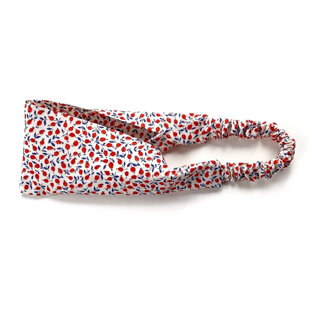 A Liberty London Tana Lawn cotton  headband with a red and navy floral pattern on a white background, featuring a gathered elastic band, photographed on a clean white background.